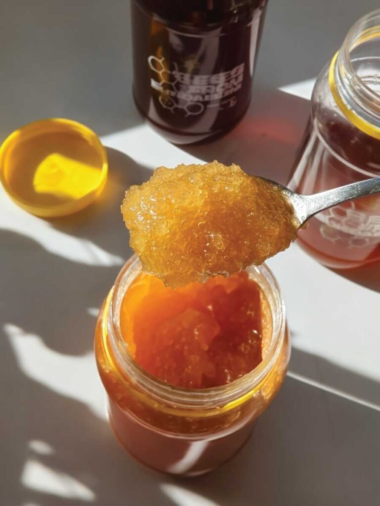 Spoonful of crystallized honey in jar