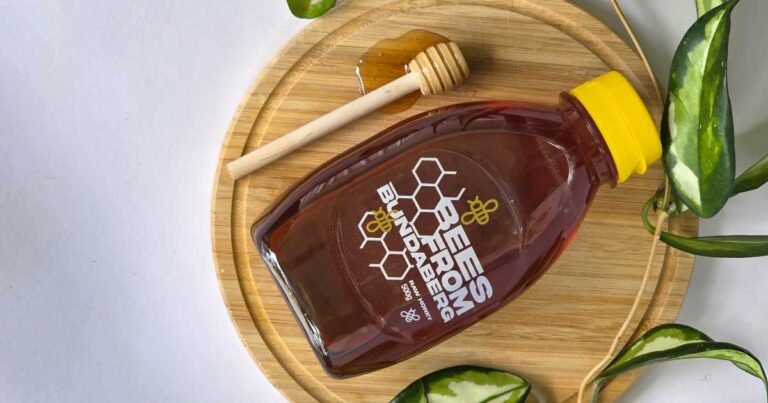 Honey jar with honey dipper and plants